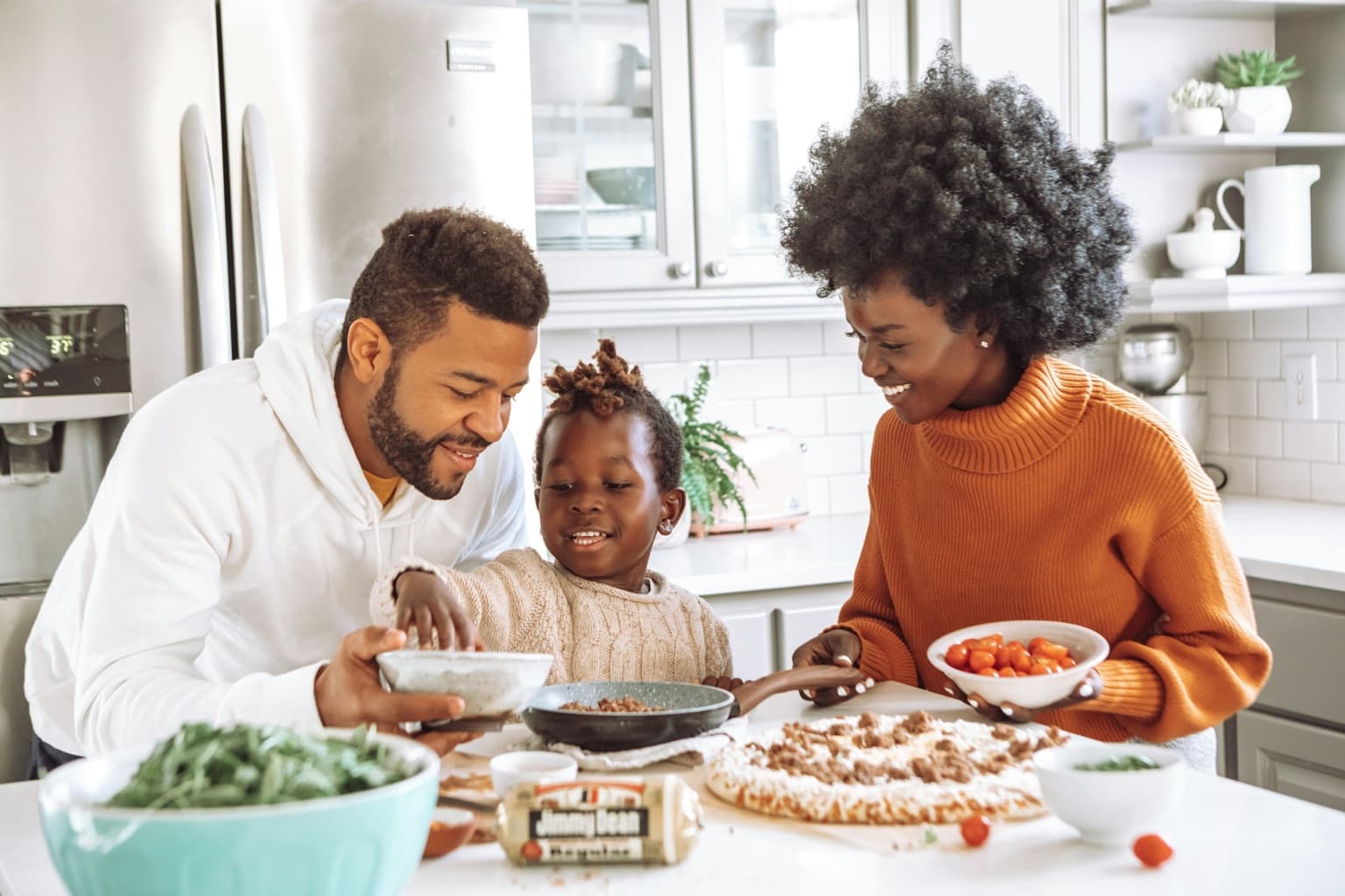 A family preparing a meal together in a sunlit kitchen.